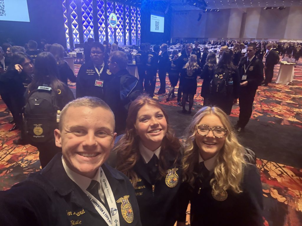 Hayden Hubbard, Amy Peldo, and Megan Hedges pose for a selfie at a state officer/delegate function during national FFA convention.